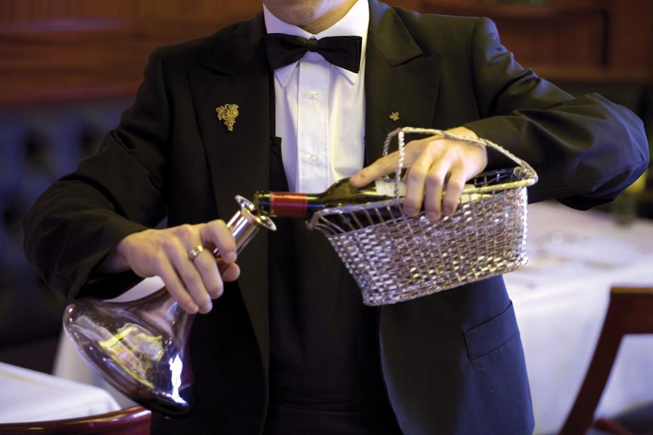 Hotel De La Cigogne Женева Экстерьер фото A sommelier serving wine